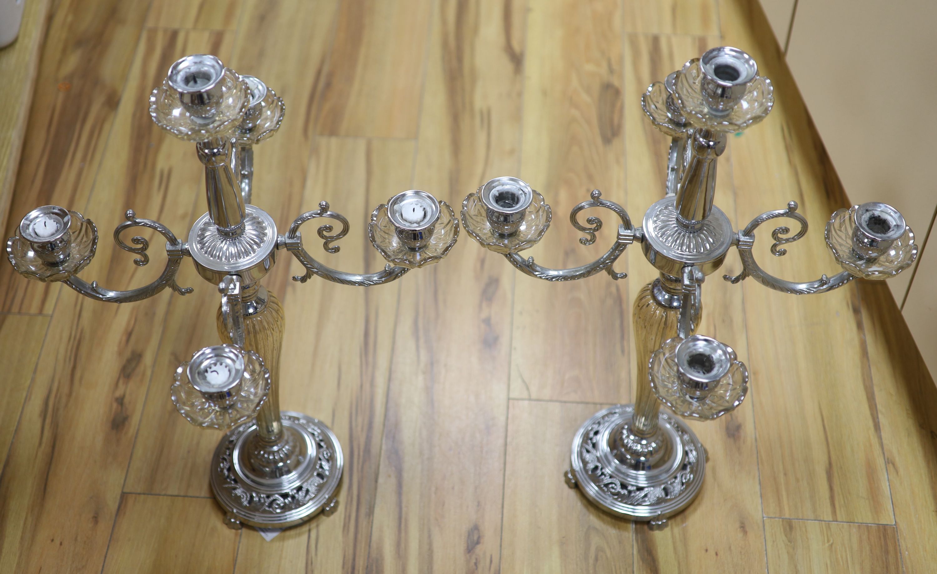 A pair of plated and glass four branch five light candelabra, height 68cm